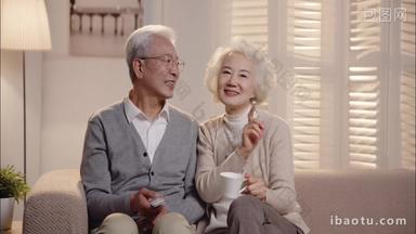 老年夫妇<strong>坐在沙发上</strong>看电视